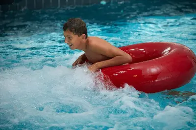 a young boy in a pool with a red raft at HimmerLand in Gatten