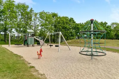 an empty playground with two swings in a park at HimmerLand in Gatten
