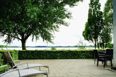a patio with chairs and tables and a tree at Golf Hotel Viborg in Viborg