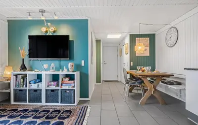 a dining room with a table and a tv on a wall at Three-Bedroom Holiday Home In Pandrup in Pandrup
