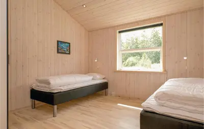 a bedroom with a bed and a window at Four-Bedroom Holiday Home In Lokken in Løkken