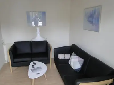 a living room with a black couch and a table at Thinghuskroen in Vestervig