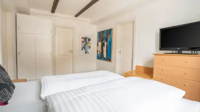 a bedroom with a bed and a flat screen tv at Palads Hotel in Viborg