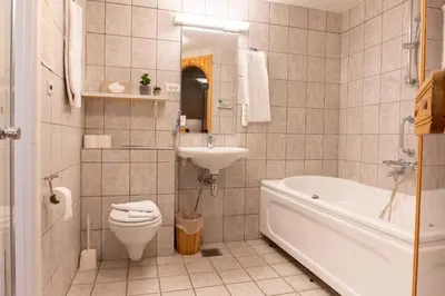 a bathroom with a toilet and a sink and a tub at Palads Hotel in Viborg