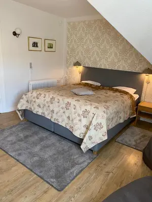 a bedroom with a large bed and a rug at Hotel Højslev Kro in Højslev