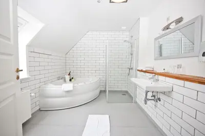 a white bathroom with a tub and a sink at Hotel Højslev Kro in Højslev