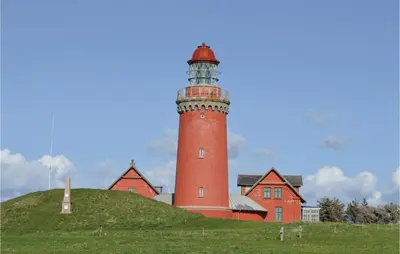 a red lighthouse sitting on top of a hill at Two-Bedroom Holiday Home In Lemvig in Lemvig