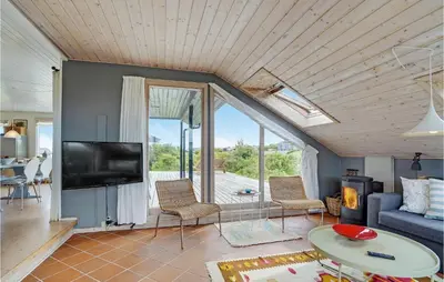 a living room with a blue couch and a tv at Two-Bedroom Holiday Home In Lemvig in Lemvig