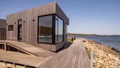 a building on a dock next to the water at Hotel Strandtangen in Skive