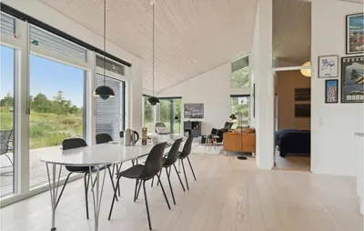 a dining room and living room with a table and chairs at Three-Bedroom Holiday Home In Fjerritslev in Fjerritslev