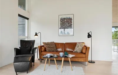 a living room with a brown couch and a chair at Three-Bedroom Holiday Home In Fjerritslev in Fjerritslev