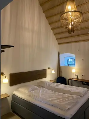 a bedroom with a bed and a chandelier at Sebber Kloster in Nibe
