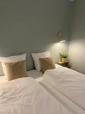 a bedroom with two beds with white sheets and pillows at Sebber Kloster in Nibe