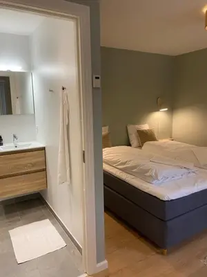 a bedroom with a bed and a sink and a mirror at Sebber Kloster in Nibe