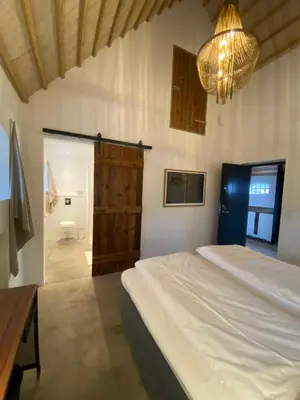a bedroom with a bed and a chandelier at Sebber Kloster in Nibe