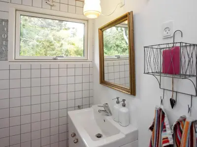 a bathroom with a sink and a window and a mirror at 4 person holiday home in Højslev in Højslev