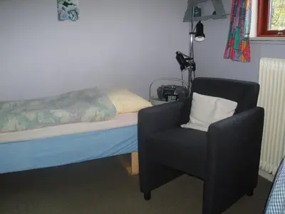 a bedroom with a bed and a chair in it at Glyngøre Bed & Breakfast in Glyngøre