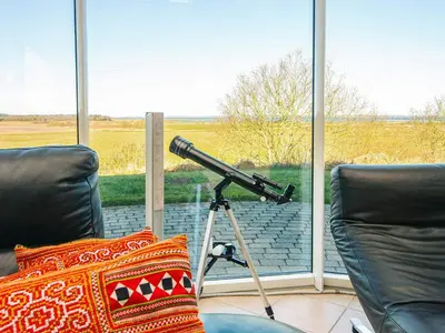 a telescope sitting on a tripod in front of a window at Luxury Fjordview Retreat-By Traum in Højslev