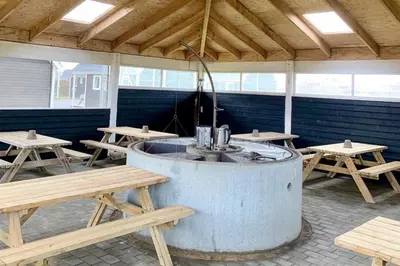 a room with picnic tables and a hot tub at Thyborøn Cottages in Thyborøn