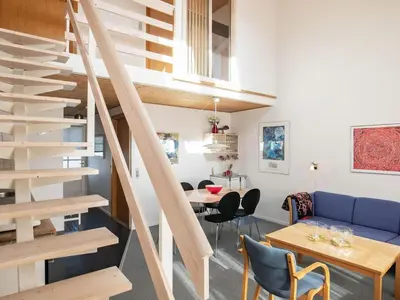 a living room with a staircase and a table and chairs at 5 person holiday home in Vestervig-By Traum in Vestervig