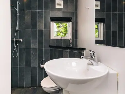 a bathroom with a sink and a toilet and a mirror at 10 person holiday home in Brovst-By Traum in Brovst