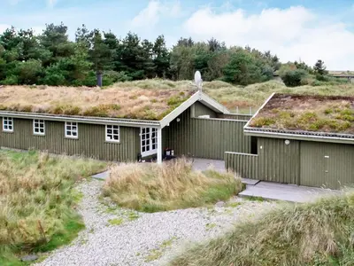 a couple of buildings with grass roofs at 6 person holiday home in Løkken-By Traum in Løkken