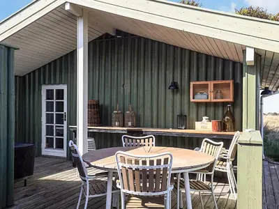 a patio with a table and chairs on a deck at 6 person holiday home in Løkken-By Traum in Løkken