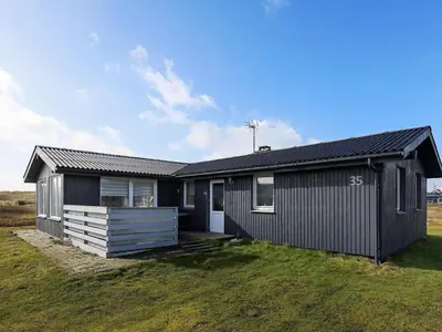a black house on a field with a grass yard at Luxury Spa Retreat near Sea - By Traum Ferienwohnungen in Ferring