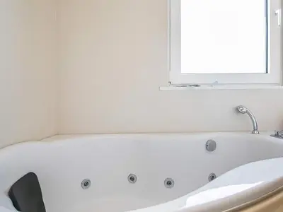 a white bath tub in a bathroom with a window at Luxury Spa Retreat near Sea - By Traum Ferienwohnungen in Ferring
