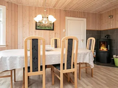 a dining room with a table and chairs and a fireplace at 6 person holiday home in Lemvig in Ferring