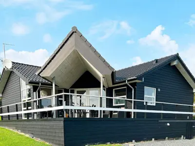 a large blue house with a roof at 8 person holiday home in Roslev-By Traum in Roslev