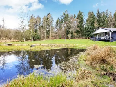 a house with a pond in front of it at 5 person holiday home in Fur-By Traum in Fur