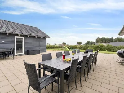 a wooden table and chairs on a patio at Luxury Retreat by Hostrup Beach - By Traum Ferienwohnungen in Spottrup