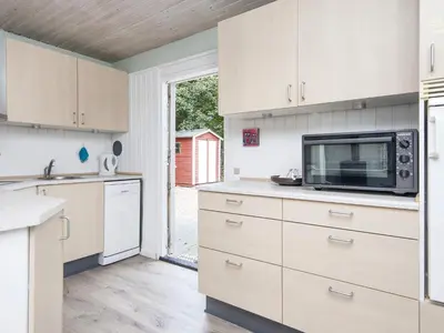 a kitchen with white cabinets and a microwave at 8 person holiday home in Struer-By Traum in Struer