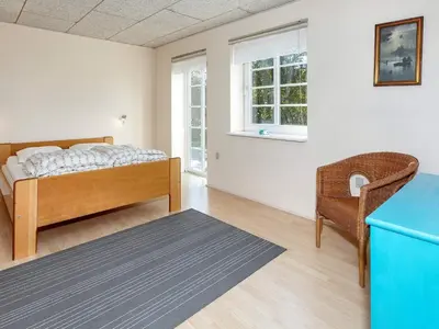 a bedroom with a bed and a chair at 10 person holiday home in Fur-By Traum in Fur