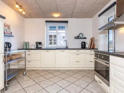 a kitchen with white cabinets and a window at 10 person holiday home in Fur-By Traum in Fur
