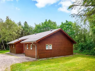 a small cabin in a field with a grass yard at 6 person holiday home in Thyholm in Thyholm