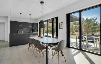 a kitchen and dining room with a table and chairs at Three-Bedroom Holiday Home In Thisted in Thisted