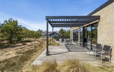 a patio with tables and chairs next to a building at Three-Bedroom Holiday Home In Thisted in Thisted
