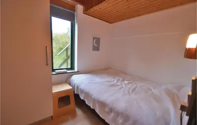 a small bedroom with a bed and a window at Three-Bedroom Holiday Home In Struer in Struer