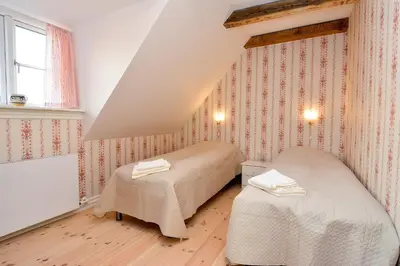 a bedroom with two beds in a attic at Strømpehuset in Øster Assels