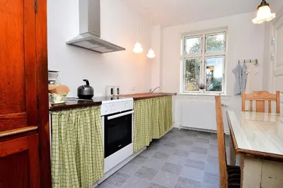 a kitchen with a sink and a stove top oven at Strømpehuset in Øster Assels