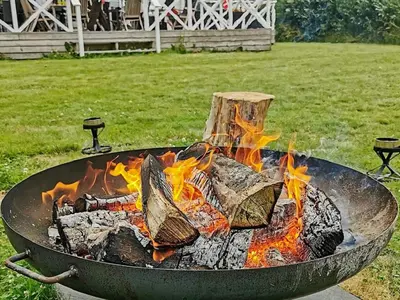 a large grill with fire in a yard at Modern Retreat at Knud Strand - By Traum Ferienwohnungen in Spottrup