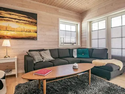 a living room with a couch and a table at Modern Retreat at Knud Strand - By Traum Ferienwohnungen in Spottrup