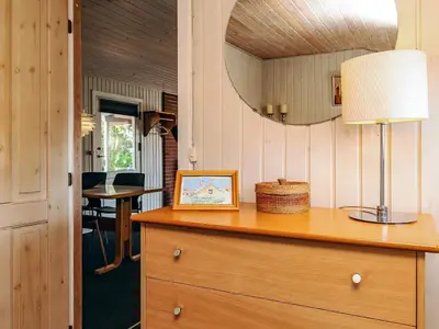 a table with a lamp on top of a dresser at 4 person holiday home in Thisted-By Traum in Nørre Vorupør