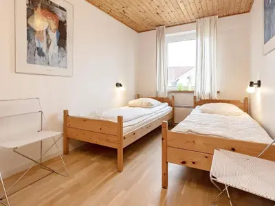 a bedroom with two beds and a window at Panoramic Seaside Escape - By Traum Ferienwohnungen in Frøstrup