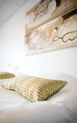 a bed with a yellow and white pillow on it at Hotel Thinggaard in Hurup