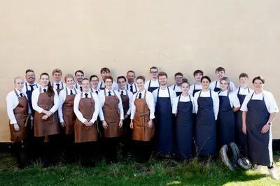 a group of men and women in uniforms posing for a picture at Hotel Thinggaard in Hurup