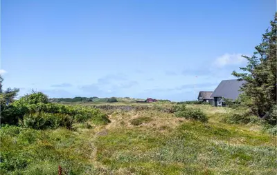 a house in the middle of a field at Lovely Home In Blokhus With Sauna in Blokhus