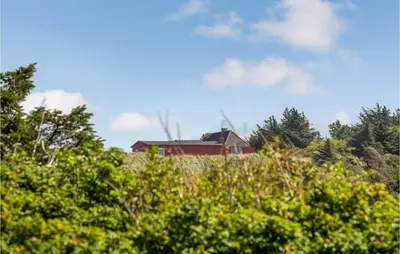 a house on top of a hill with trees at Lovely Home In Blokhus With Sauna in Blokhus